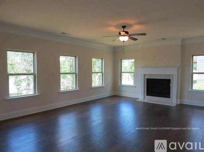 A spacious room with a fireplace and a ceiling fan.
