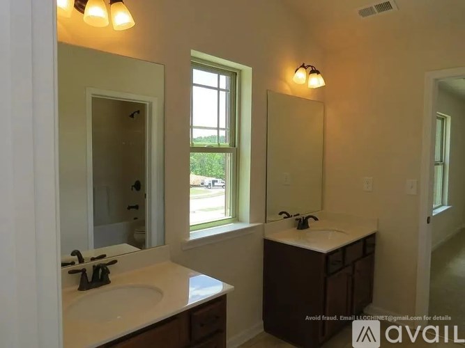 A bathroom with a sink, mirror, and window.