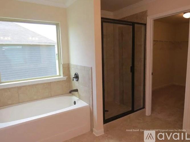 A bathroom with a tub, shower, and a window.