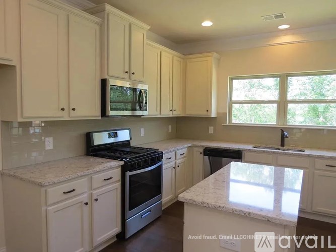 A kitchen with white cabinets and a granite countertop.