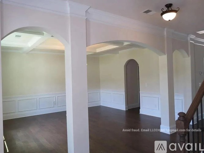 A spacious room with arched doorways and a staircase.