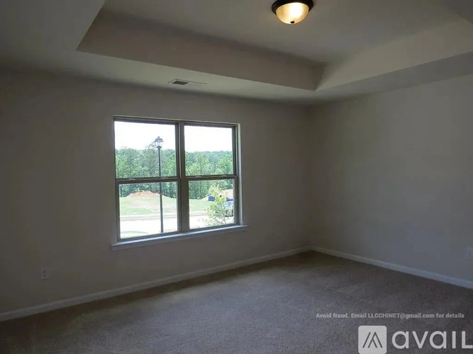 A room with a large window and a carpeted floor.