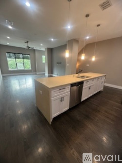A modern kitchen with a large island and wooden floors.