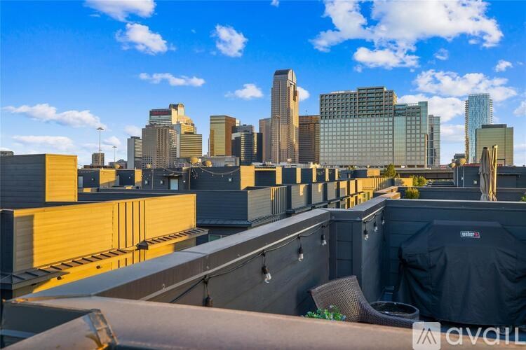 A rooftop patio with a view of a city skyline.