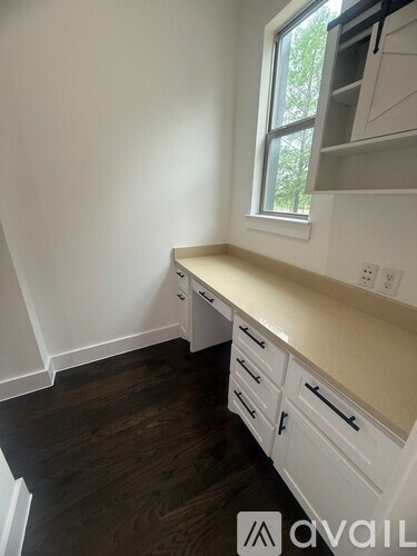 A kitchen with white cabinets and a window.