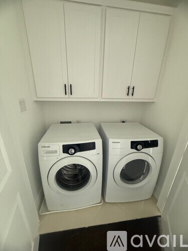 Two front loading washing machines in a small laundry room.