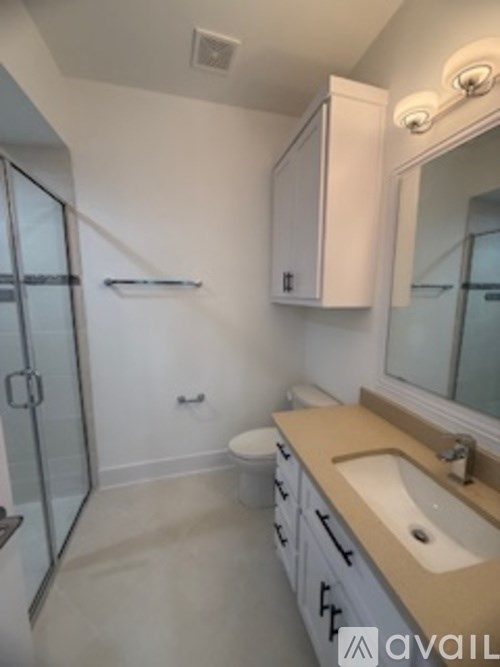 A bathroom with a sink, toilet and shower.