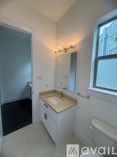 A bathroom with a sink, mirror, and toilet.