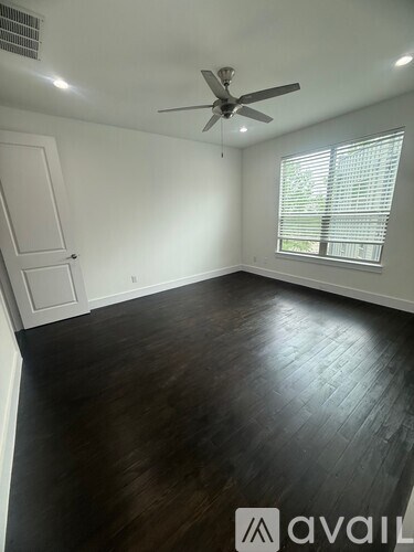 A room with a ceiling fan and a window with blinds.