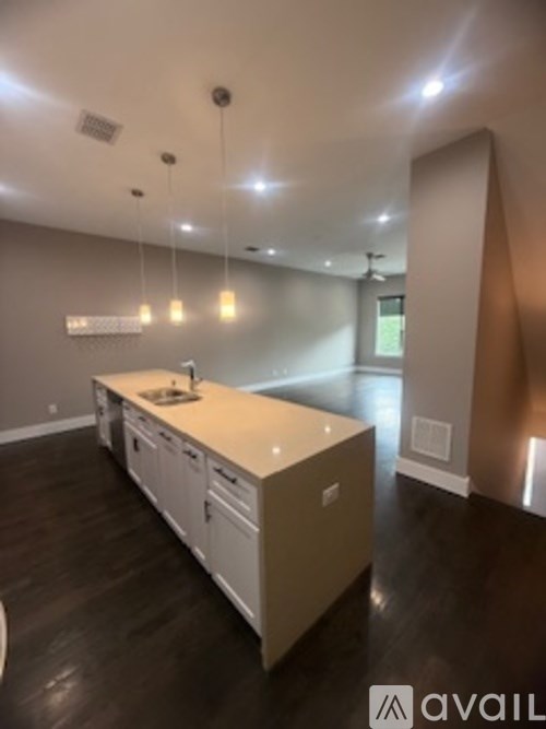 A kitchen with a white counter top and wooden cabinets.