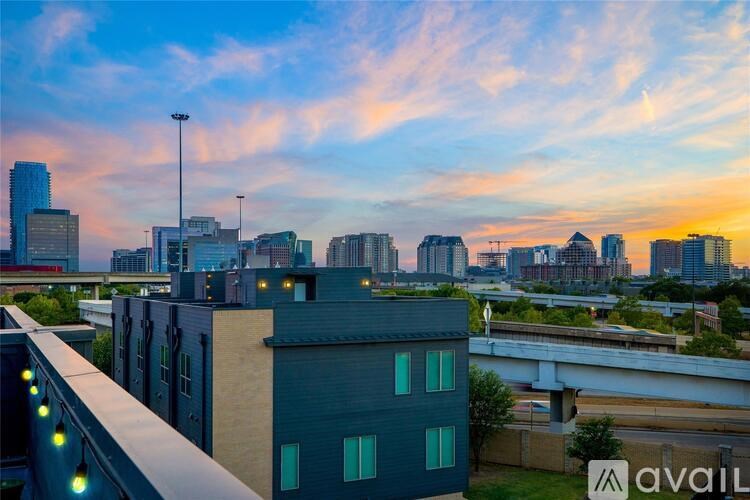 A cityscape with a building in the foreground and a sunset in the background.