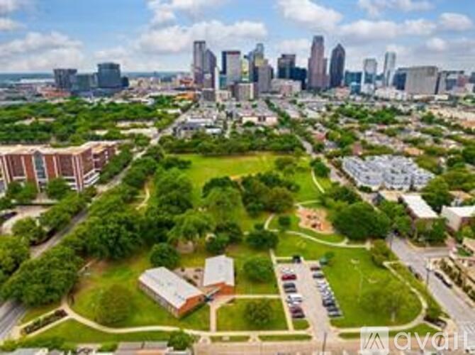 A cityscape with a green field in the foreground.