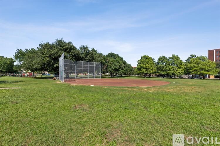 A baseball field with a batting cage in the background.