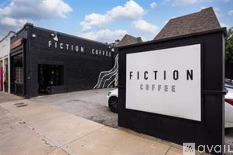 A black and white sign for Fiction Coffee in front of a building.