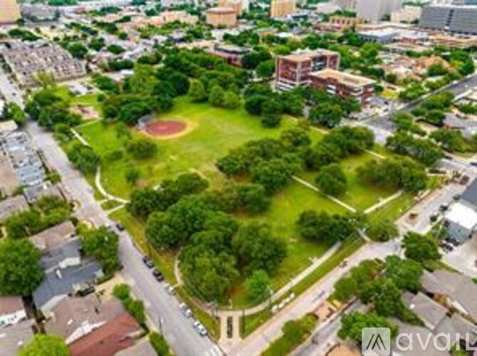 An aerial view of a park with a baseball diamond surrounded by trees and buildings.