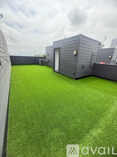 A backyard with a green lawn and a shed.