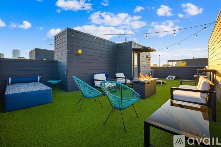 A patio with a table, chairs and a fire pit.
