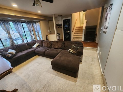A living room with a brown couch and a carpet.