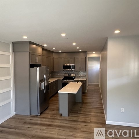A kitchen with wooden cabinets and a refrigerator.