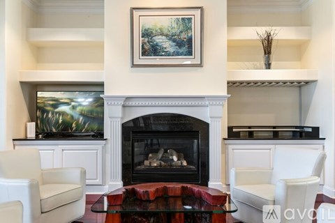 A living room with a fireplace and a painting on the wall.