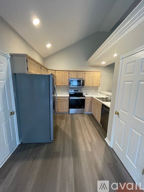 A kitchen with a refrigerator, microwave, and oven.