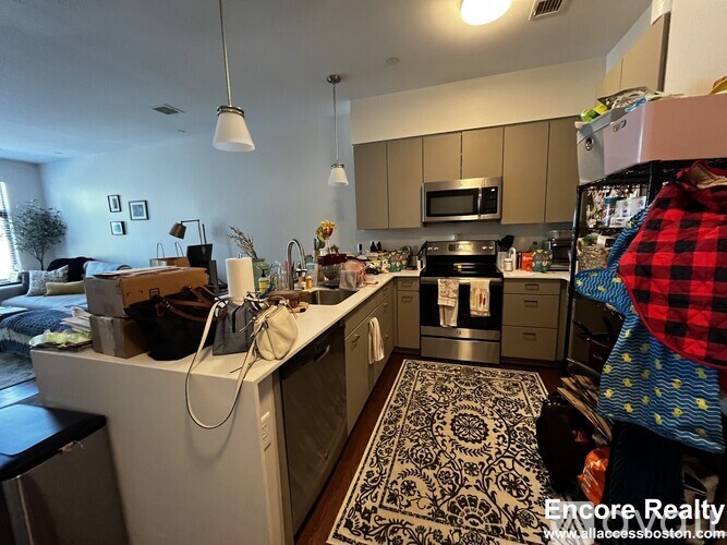 A kitchen with a black and white patterned rug on the floor.
