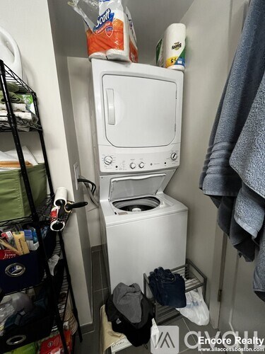 A small white toilet is in a very small bathroom.