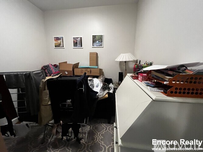 A room with a piano and boxes on the floor.
