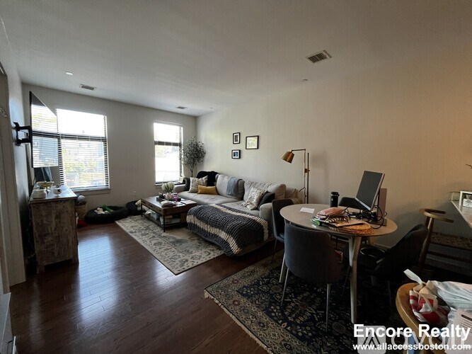 A living room with a couch, chair, and table.