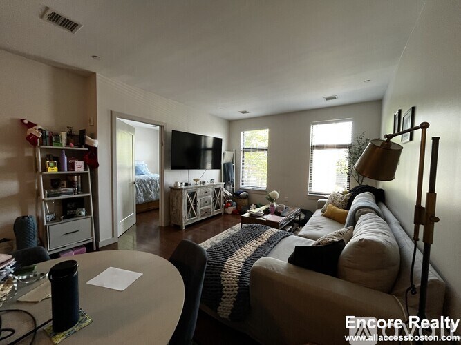 A living room with a couch, a table, and a television.