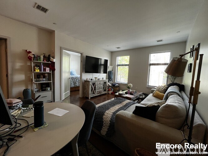 A living room with a couch, a table, and a television.