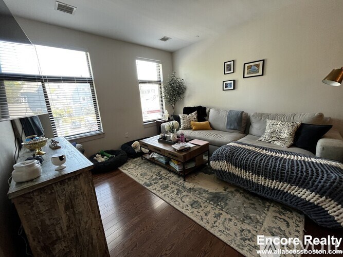 A well-lit living room with a sofa, coffee table, and a rug.