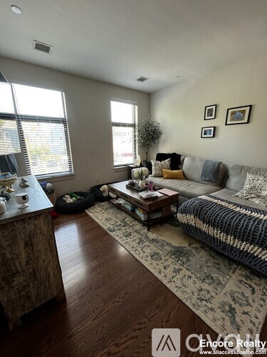A living room with a couch, coffee table, and pictures on the wall.