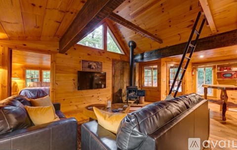 A living room with a grey couch and a wooden ceiling.