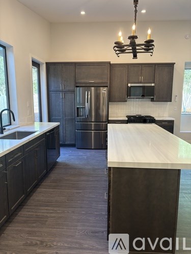A kitchen with a white counter top and dark wood cabinets.
