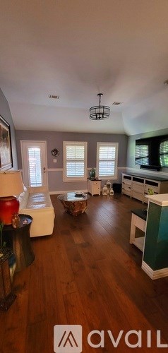 A living room with a white sofa and a wooden floor.