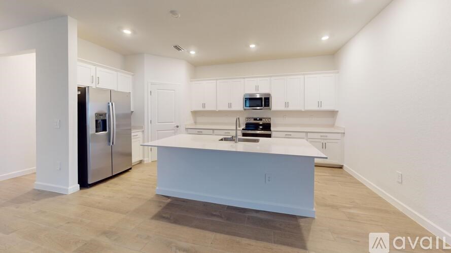 A kitchen with a refrigerator, microwave, and oven.