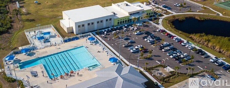 An aerial view of a swimming pool and a parking lot.