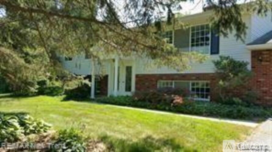 A house with a white front porch and a green lawn.