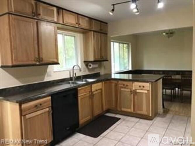 A kitchen with wooden cabinets and black countertops.