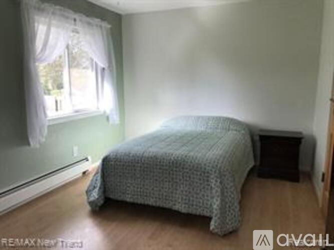 A bedroom with a bed and a window.
