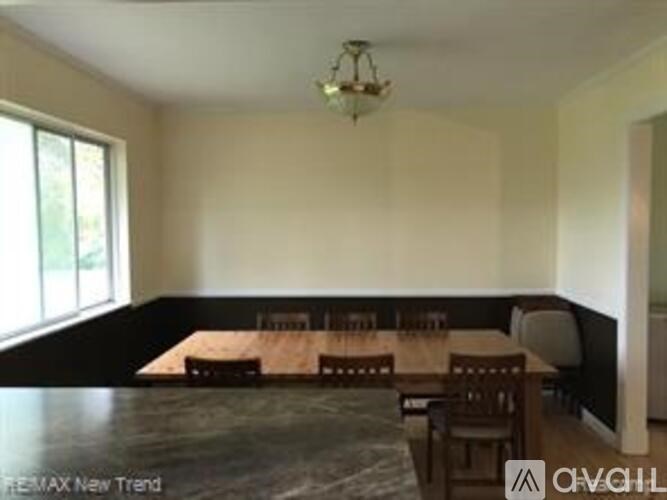 A dining room with a long table and chairs.