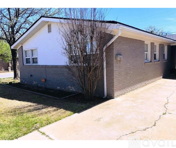 A house with a grey roof and a white wall is shown.