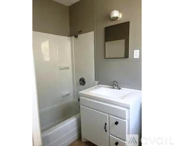A bathroom with a white sink and a white bathtub.