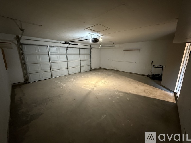 A spacious garage with a white door and a concrete floor.