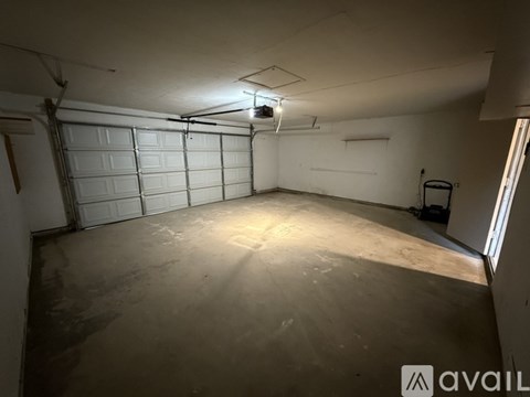 A spacious garage with a white door and a concrete floor.