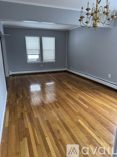 A room with wooden flooring and a chandelier.
