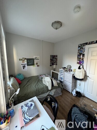 A bedroom with a bed, desk, and chair.