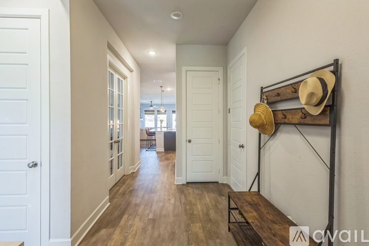 A hallway with a coat rack and hats hanging on it.