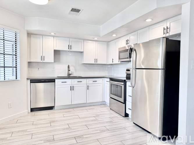 A modern kitchen with stainless steel appliances and white cabinets.